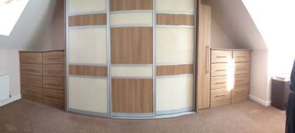 Panoramic of wardrobe between the eaves with fitted drawers at both sides